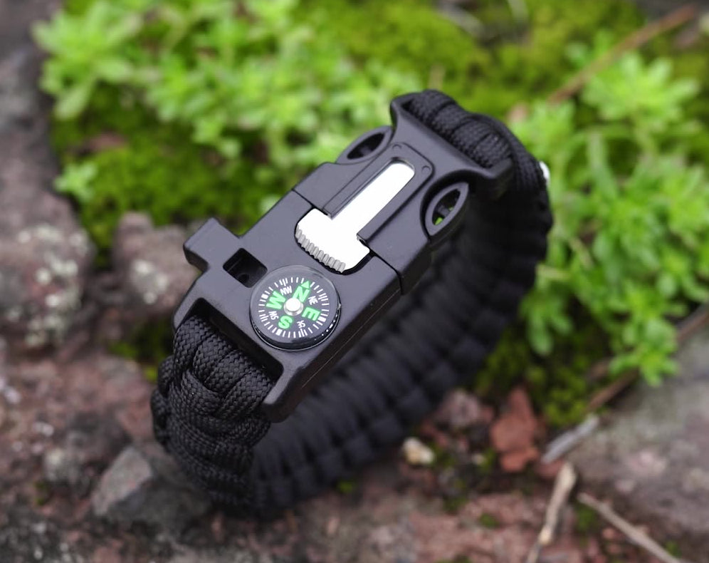 צמיד הישרדות הכולל אבן אש, מיתר, מצפן ומשרוקית. מבית CampX